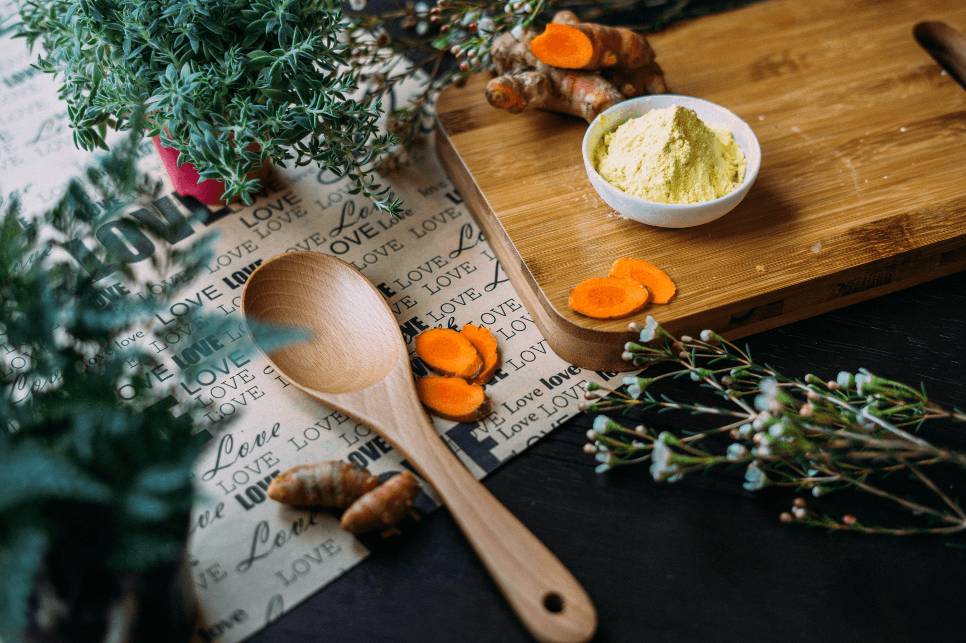 Small bowl filled with orange, powered herb, surrounded by plants